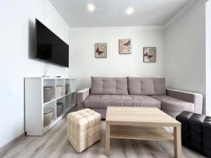 ein Wohnzimmer mit einem Sofa und einem Tisch in der Unterkunft Квартира в элитном ЖК in Pawlodar