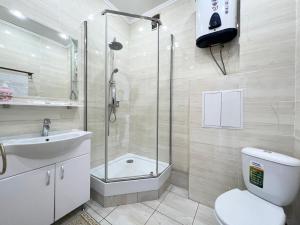 ein Bad mit einer Dusche, einem WC und einem Waschbecken in der Unterkunft Квартира в элитном ЖК in Pawlodar