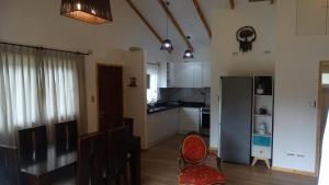 a kitchen with white cabinets and a table and chairs at Parcela Parulus in Valdivia