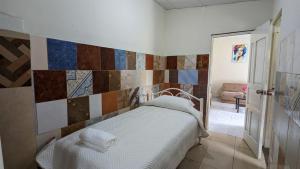 1 dormitorio con cama y pared de azulejos en La casita, en Cochabamba