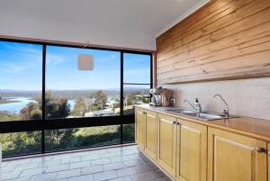 a kitchen with a sink and a large window at Aqua La Vista - 4 Bedroom Pet Friendly House in Merimbula +29 photos