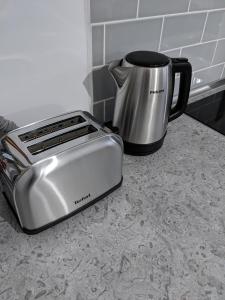 a toaster sitting on a counter next to a coffee pot at Alina's Deluxe Apartment and free private parking in Dumbrăviţa
