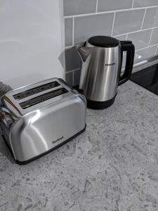 einen Toaster, der auf einer Theke neben einer Kaffeekanne sitzt in der Unterkunft Alina's Deluxe Apartment and free private parking in Dumbrăviţa