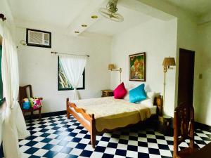 a bedroom with a bed and a checkered floor at M Villa’s Farm Resort in Romblon