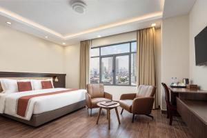 Cette chambre comprend un lit et une grande fenêtre. dans l'établissement HM Grand Central Hotel, à Phnom Penh