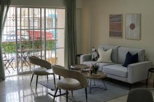 聖多明各的住宿－Hermoso Apartamento Cerca de la Embajada Americana，客厅配有沙发、椅子和桌子
