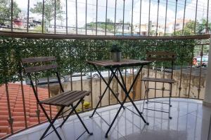 2 sillas y una mesa en el balcón en Hermoso Apartamento Cerca de la Embajada Americana, en Santo Domingo