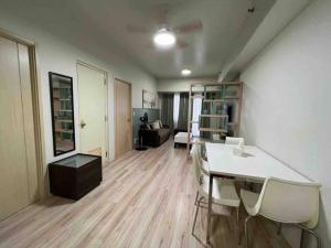 uma sala de estar com uma mesa e cadeiras num quarto em 2 BR Condo Jazz cozy at best deal! em Manila