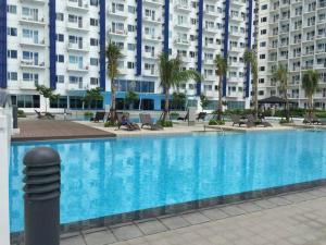a large swimming pool in front of a large building at 2 BR Condo Jazz cozy at best deal! in Manila