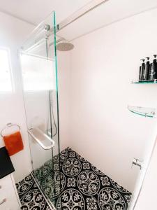 um chuveiro com uma porta de vidro na casa de banho em Beach Boutique With River View em Maroochydore