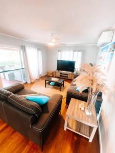 uma sala de estar com um sofá de couro e uma mesa em Beach Boutique With River View em Maroochydore