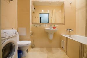 ein Badezimmer mit einem WC, einem Waschbecken und einer Waschmaschine in der Unterkunft Pechersky Kvartal Apartments in Kiew