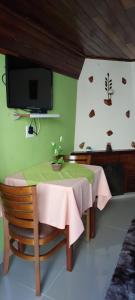 モンテ・ヴェルデにあるCasa Moreira´s Chalésのダイニングルーム(テーブル、壁掛けテレビ付)