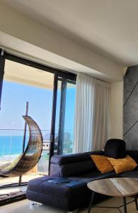 a living room with a couch and a view of the ocean at Bat Yam Luxery 5BR Sea View Suite in Bat Yam
