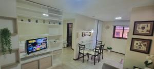 a living room with a television and a table and chairs at Solar de Pipa Elegance Flat - Frente Piscina in Pipa