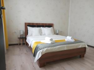 a bedroom with a bed with two towels on it at VILA DAVISON in Târgu Jiu