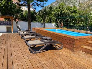 une rangée de chaises longues à côté d'une piscine dans l'établissement Villa Spring, à Meta