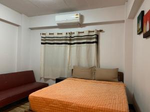 - une chambre avec un lit et un canapé dans l'établissement Chiangmai HomeTeL, à Chiang Mai