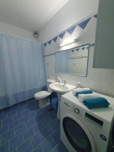 een badkamer met een wasmachine en een wastafel bij Vivis house in Katochorion