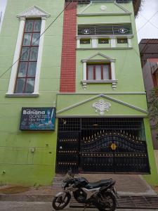 una motocicleta estacionada frente a un edificio verde en YP villa, en Pondicherry