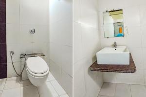 a bathroom with a white toilet and a sink at FabHotel Kadamb Inn in Ahmedabad