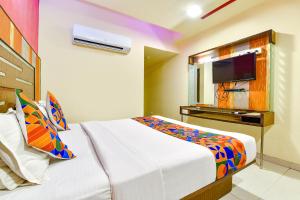 um quarto de hotel com uma cama e uma televisão em FabHotel Kadamb Inn em Ahmedabad