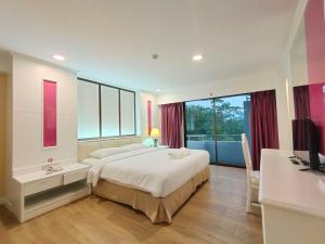 a bedroom with a large bed and a large window at Ebina House - SHA Extra Plus in Bangkok