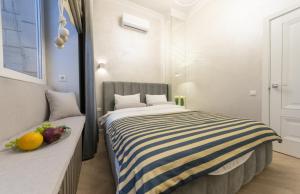 Dormitorio con cama de rayas y fruta en una mesa en V&V luxury apartments (Arena City,Maydan), en Kiev