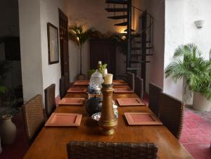 - une longue table en bois dans une chambre avec des chaises dans l'établissement Casa Gaitana - Alma Hotels, à Santa Marta