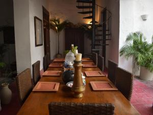 a long wooden table in a room with chairs at Casa Gaitana - Alma Hotels in Santa Marta