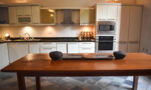 a kitchen with a wooden table in the middle at Casa Gaitana - Alma Hotels in Santa Marta