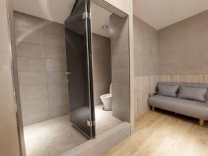 een badkamer met een douche, een bank en een toilet bij 麗詩旅海景民宿 in Magong