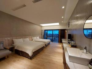 een hotelkamer met 2 bedden en een wastafel bij 麗詩旅海景民宿 in Magong