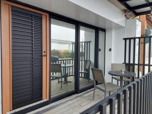 馬公市的住宿－麗詩旅海景民宿，阳台设有玻璃门和桌椅。