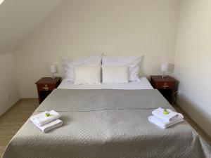 a bedroom with a large bed with towels on it at Penzion Za radnicí in Valtice