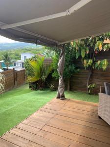 une terrasse avec un auvent sur une pelouse dans l'établissement Kasamia vue mer à St Leu, à Saint-Leu