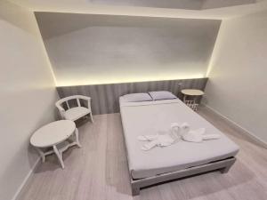 โรงแรมเกียรตินคร (Kiatnakhon Hotel) في ناخون سي ثامارات: غرفة صغيرة بها سرير وكرسي