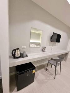 a white desk with a chair and a mirror at โรงแรมเกียรตินคร (Kiatnakhon Hotel) in Nakhon Si Thammarat