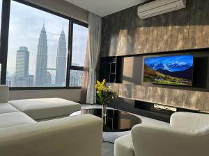 uma sala de estar com mobiliário branco e uma televisão em ASTRA @ 8 Kia Peng Suites em Kuala Lumpur