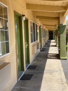 an empty hallway of a building with green doors at Holiday Motel in Morgan Hill