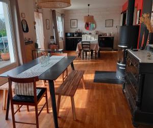 cocina y sala de estar con mesa y fogones en Chambres d'hôtes Avel Glaz, en Morlaix