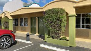 a building with a bush on the side of it at Holiday Motel in Morgan Hill