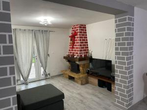 een woonkamer met een bakstenen open haard en een tv bij Appartamento Giotto in Cento