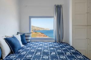 a bedroom with a bed with a view of the ocean at Mykonos Citadel in Mikonos
