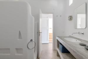 a white bathroom with a sink and a mirror at Mykonos Citadel in Mikonos +29 photos