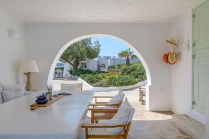 a dining room with a table and chairs and an archway at Mykonos Citadel in Mikonos