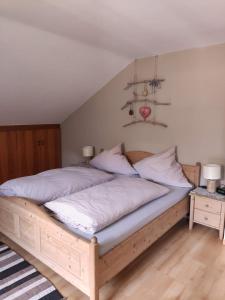 ein Schlafzimmer mit einem großen Holzbett mit weißer Bettwäsche in der Unterkunft Ferienwohnungen Kral in Grainau