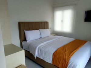 a bedroom with a large bed with a window at Batik Oma House in Jetis