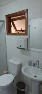 uma casa de banho com um WC, um lavatório e uma janela em Casa Moreira´s Chalés em Monte Verde