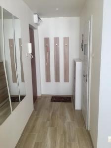 a room with white walls and wooden floors and mirrors at Uroczy apartament w Giżycku in Giżycko